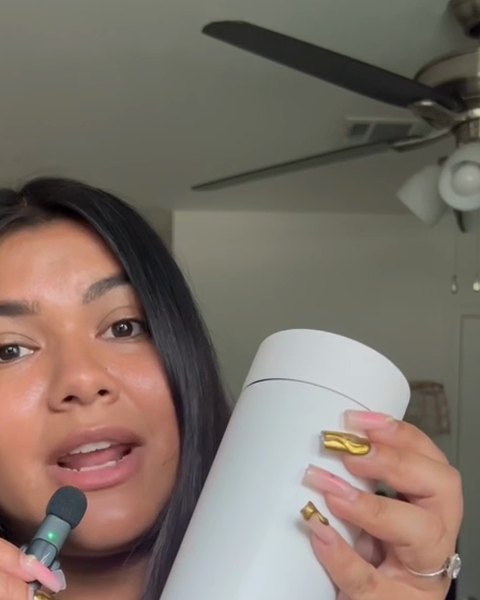 A woman holding a white Firebelly travel mug